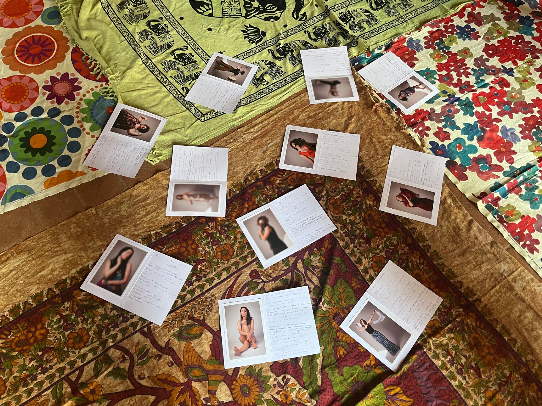 Polaroid con scritte disposte in cerchio su tappeti e stoffe colorate